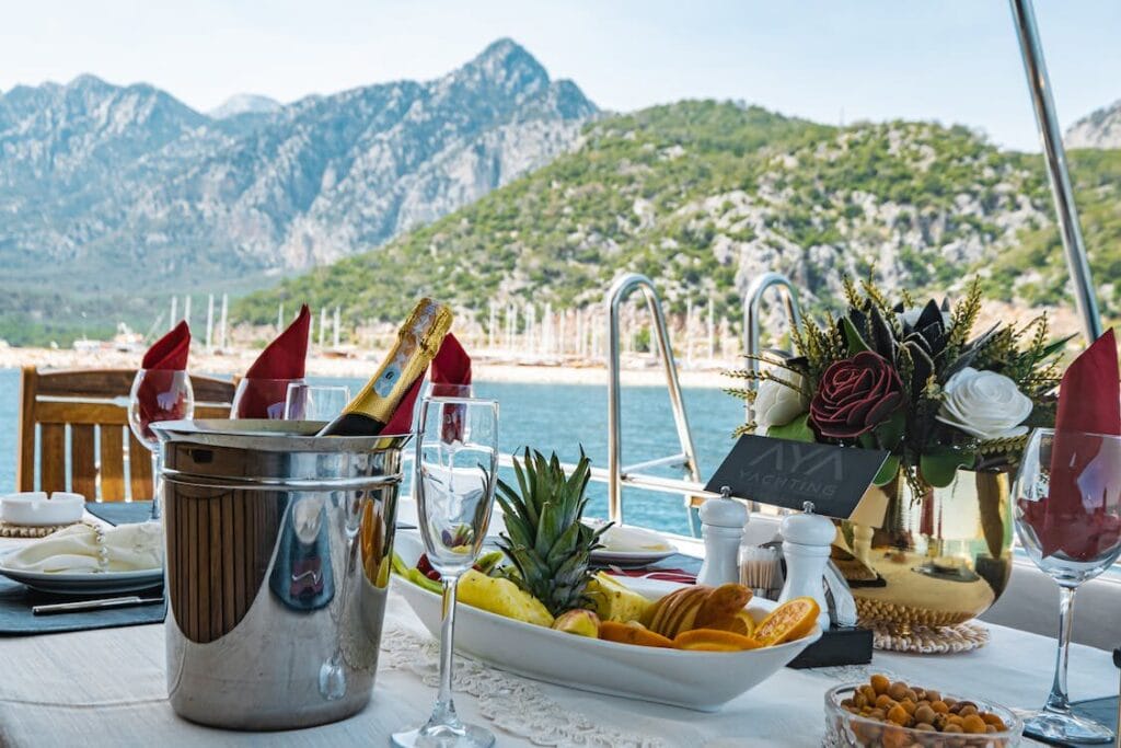 A beautifully set dining table with exquisite food on a luxury yacht overlooking the sea, symbolizing the epitome of romantic seaside dining.