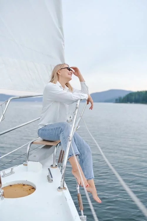 A woman in a crisp white shirt and blue jeans embracing the nautical chic look