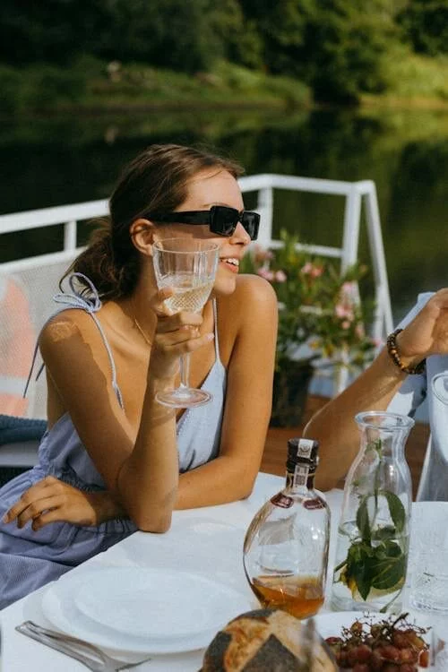 a woman is enjoying her drink on a yacht trip