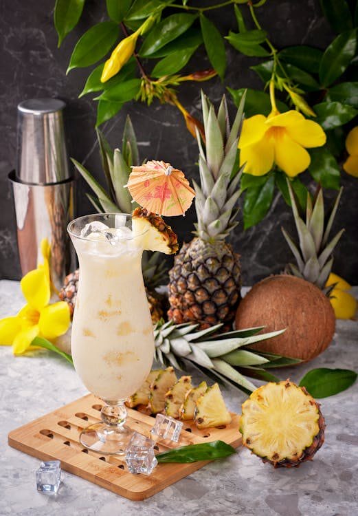 Pineapple and coconut cocktail with ice cubes and a little umbrella